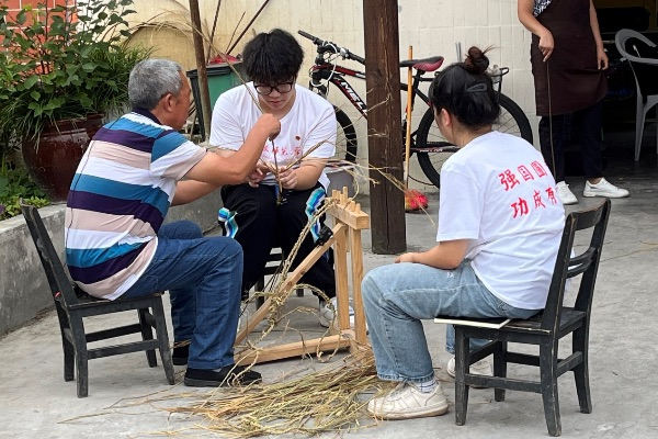 团队成员学习编织草鞋。伟德国际英国供图