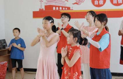 志愿者与小朋友一起跳手势舞。伟德国际英国供图