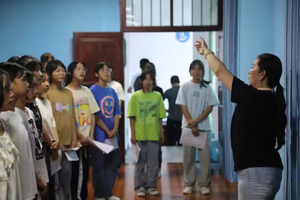 带队教师指导中学生练习齐唱。伟德国际英国供稿图